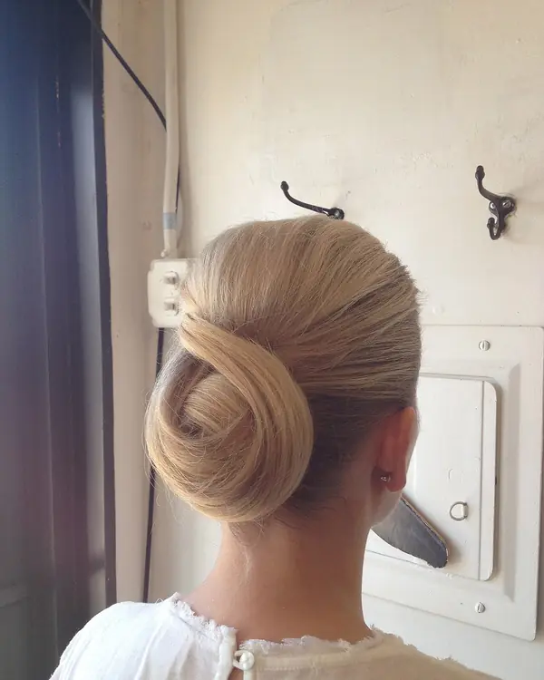 A smooth blonde twisted chignon seen from behind.