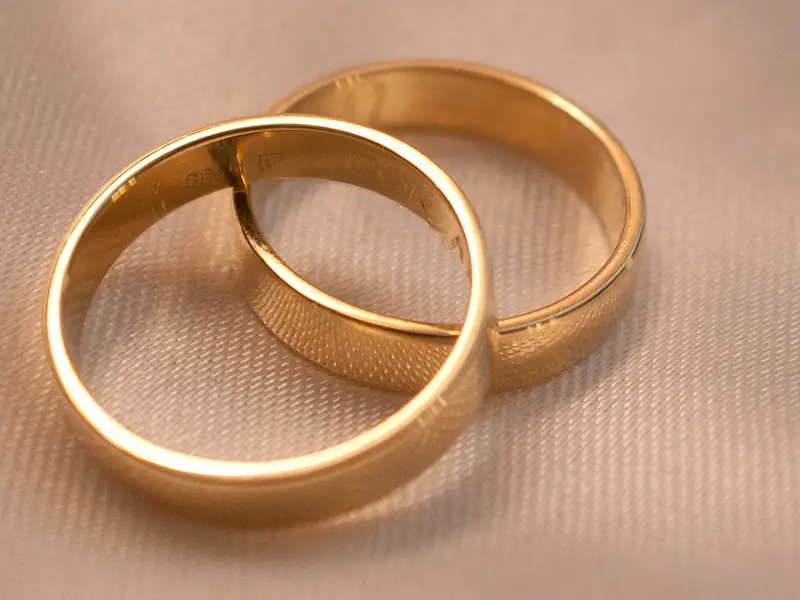 Two plain gold bands side by side on cream cloth.